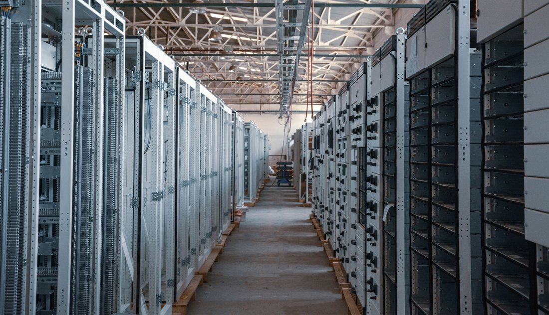 Rows of electrical switchgear staged inside a warehouse